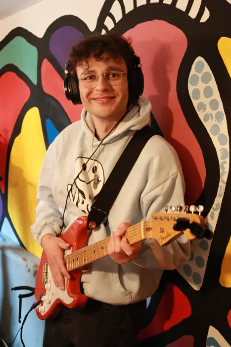 Gitarrist von Insider vor einer bunten Wand